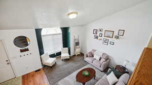 Living area with wood finished floors, baseboards, and a textured ceiling