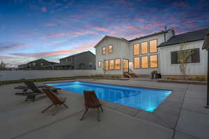 View of swimming pool featuring fence, a patio area, a fenced in pool, and entry steps