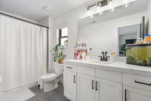 Bathroom featuring shower / bath combo, visible vents, toilet, and vanity