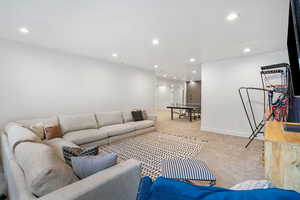Living room featuring light colored carpet, baseboards, and recessed lighting