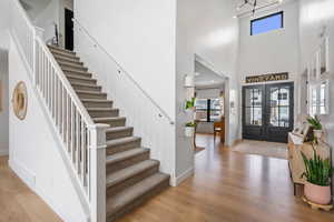 Entryway with wood finished floors, stairs, a high ceiling, french doors, and baseboards