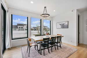 Dining room with recessed lighting, light wood-style floors, visible vents, and a notable chandelier