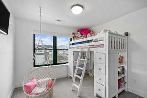 Carpeted bedroom with baseboards and visible vents