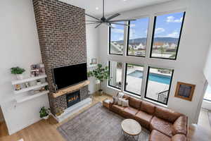 Living room with recessed lighting, wood finished floors, baseboards, a large fireplace, and ceiling fan