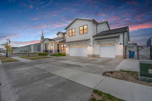 View of front of property with fence, concrete driveway, board and batten siding, a standing seam roof, and a garage