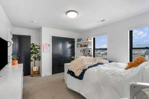 Bedroom with visible vents, baseboards, and light carpet