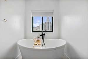 Full bath featuring a freestanding bath and baseboards