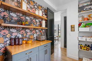 Bar featuring light wood-type flooring and baseboards