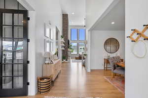 Foyer featuring light wood finished floors, baseboards, a towering ceiling, recessed lighting, and ceiling fan