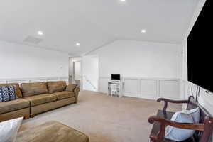 Living area featuring recessed lighting, a wainscoted wall, visible vents, light carpet, and a decorative wall