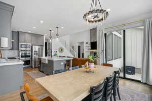Dining space featuring stairway, a chandelier, light wood-style floors, and recessed lighting