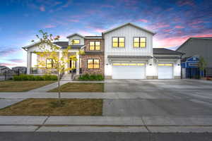 View of front of house with concrete driveway, fence, a garage, board and batten siding, and a front yard