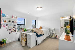 Bedroom with light colored carpet and baseboards