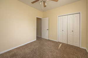 Bedroom 3 featuring baseboards, a ceiling fan, carpet flooring, and a closet