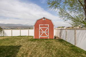 View of shed with a fenced backyard and a mountain view