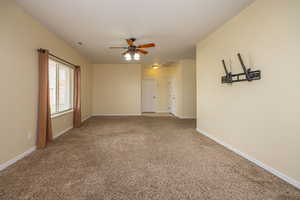 Unfurnished room featuring visible vents, baseboards, carpet flooring, and ceiling fan