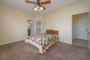 Primary bedroom featuring baseboards, carpet floors, and ceiling fan
