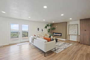 Living area featuring baseboards, recessed lighting, french doors, and light wood-style flooring