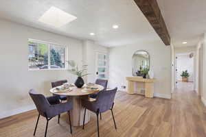 Dining space featuring recessed lighting, light wood-style flooring, a skylight, and baseboards