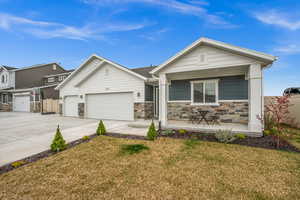 Ranch-style home featuring a front lawn, driveway, a porch, stone siding, and a garage