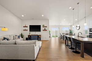Living area with baseboards, wood finished floors, visible vents, and recessed lighting