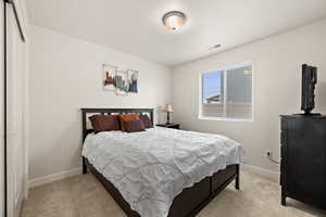 Bedroom featuring visible vents, baseboards, and light carpet