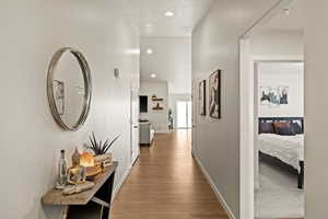 Hallway with recessed lighting, wood finished floors, and baseboards