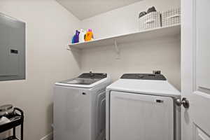 Laundry area featuring separate washer and dryer, electric panel, and laundry area