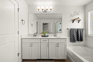 Full bath with a bath, a shower stall, a sink, and double vanity