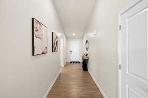 Hallway with baseboards, light wood finished floors, and recessed lighting