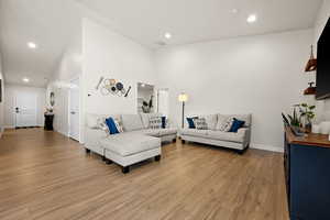 Living area featuring light wood finished floors, visible vents, and recessed lighting