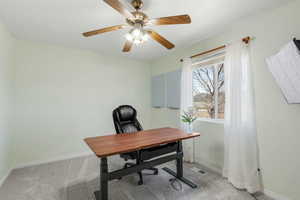 Office featuring light carpet, baseboards, visible vents, and a ceiling fan