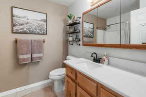 Full bathroom featuring tile patterned floors, vanity, a shower with curtain, baseboards, and toilet