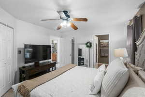 Bedroom featuring a ceiling fan, baseboards, and connected bathroom