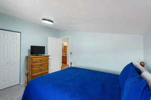 Bedroom featuring light colored carpet and a closet