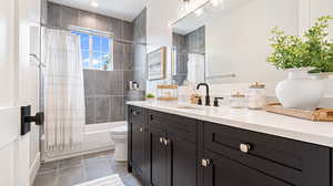 Bathroom featuring toilet, vanity, tile patterned floors, and shower / bathtub combination with curtain