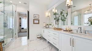 Full bathroom featuring an inviting chandelier, visible vents, a sink, and a marble finish shower