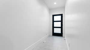 Doorway with baseboards, visible vents, recessed lighting, and light tile patterned floors