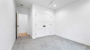 Unfurnished bedroom featuring a closet, visible vents, carpet flooring, and baseboards