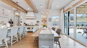 Dining area featuring recessed lighting, an inviting chandelier, beamed ceiling, and light wood-type flooring
