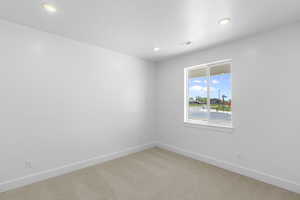 Unfurnished room featuring light carpet, visible vents, and baseboards