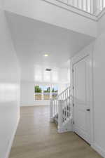 Corridor featuring recessed lighting, stairway, visible vents, baseboards, and light wood-style flooring
