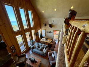 Living room with plenty of natural light, wood finished floors, high vaulted ceiling, and recessed lighting