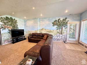 Carpeted living area with tile patterned flooring, recessed lighting, and a textured ceiling