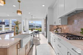 Kitchen with custom exhaust hood, a wealth of natural light, appliances with stainless steel finishes, and recessed lighting