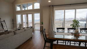 Dining room with baseboards, a healthy amount of sunlight, a mountain view, and lofted ceiling