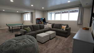 Living room with baseboards, dark carpet, and recessed lighting