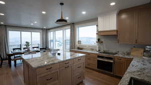 Kitchen featuring recessed lighting, black electric cooktop, wood finished floors, and stainless steel oven
