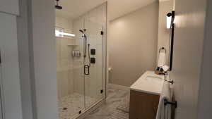 Full bath with baseboards, vanity, marble finish floor, and a stall shower