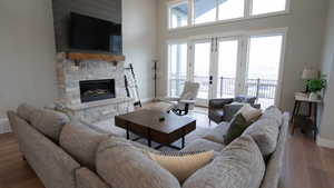 Living area with baseboards, wood finished floors, and a stone fireplace